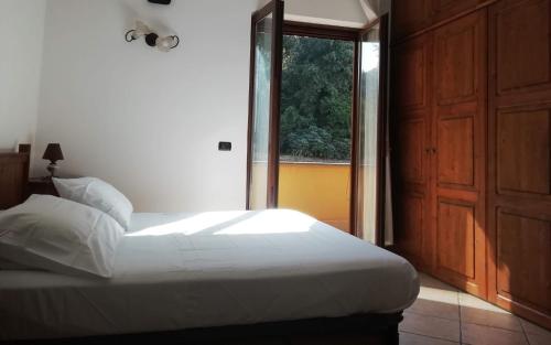 Un dormitorio con una cama blanca y una ventana. en Casa Verde, en Nápoles
