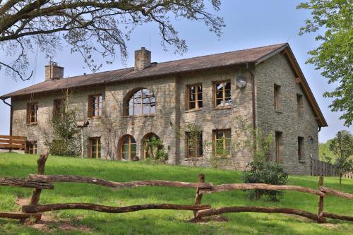 バート・ラウターベルクにあるAußergewöhnliche Ferienwohnungen im Cottage im Harz - Earl's Lane - Schottland im Harzの前面に木製の柵を持つ古い石造りの家