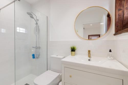 Baño blanco con lavabo y espejo en Casa Canaria Azucena, en Los Llanos de Aridane