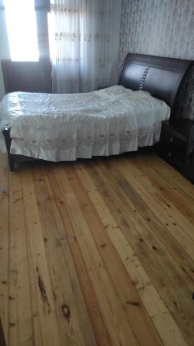 a bedroom with a bed and a wooden floor at AYXAN HOSTEL in Ganja