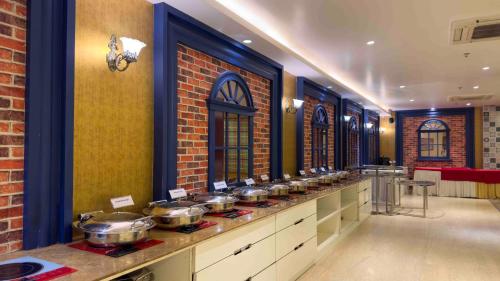 kuchnia z garnkami i patelniami na ladzie w obiekcie WoodApple Residency w Nowym Delhi