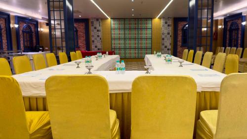 a long table in a room with yellow chairs at WoodApple Residency in New Delhi