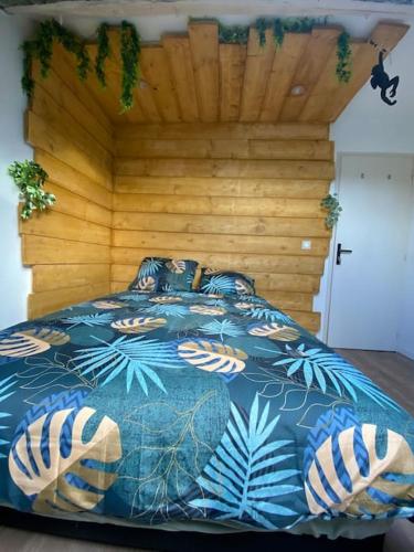 a bedroom with a bed with a wooden wall at Jungle Cosy in Louviers