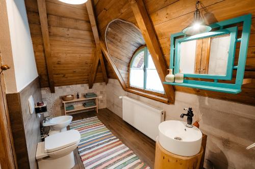 an attic bathroom with a sink and a mirror at La bujda lu mosu in Borşa