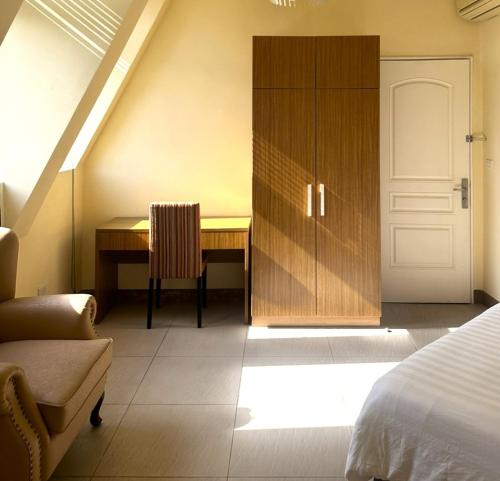 1 dormitorio con cama, escritorio y puerta en Polaris Hotel, 