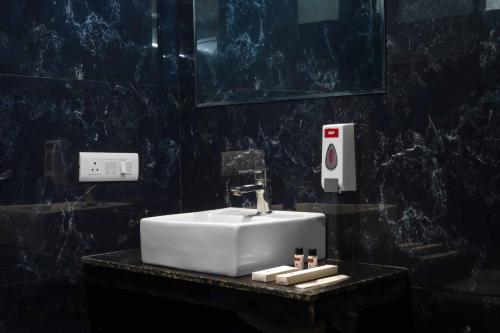 a bathroom with a white sink and a mirror at WoodApple Residency in New Delhi