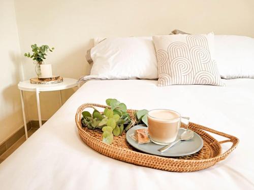 a tray with a cup of coffee and a plant on a bed at Apartamento con piscina y vistas a la montaña in Denia