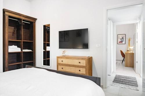 a bedroom with a bed and a tv on a wall at Sweet and rural home in Ra’anana in Ra‘ananna