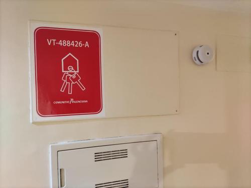 a red and white sign on a wall at Apartamento con piscina y vistas a la montaña in Denia