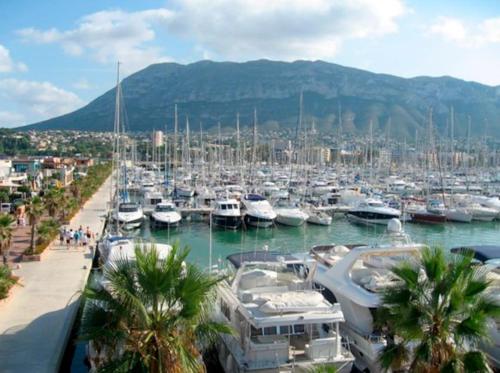 a bunch of boats docked in a harbor at Apartamento con piscina y vistas a la montaña in Denia