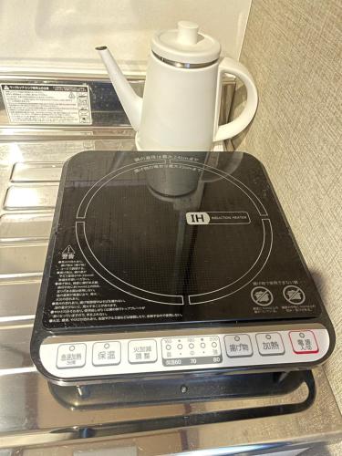 a remote control sitting on top of a stove at 難波心斎橋10 minutes民宿3号室 in Osaka