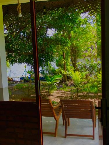 two benches sitting in front of a window at Wilpattu Green Cabin in Achchamulai