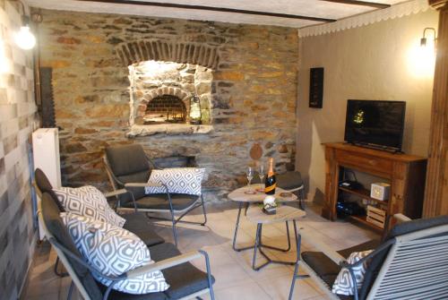 a living room with chairs and a stone fireplace at Au Four in Bras-Haut
