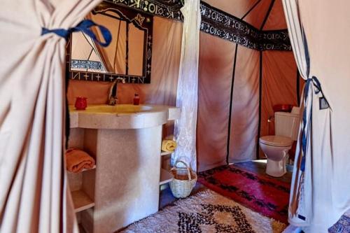 a bathroom with a sink and a toilet in a tent at Merzouga Highdune Camp With Heated Tents in Merzouga