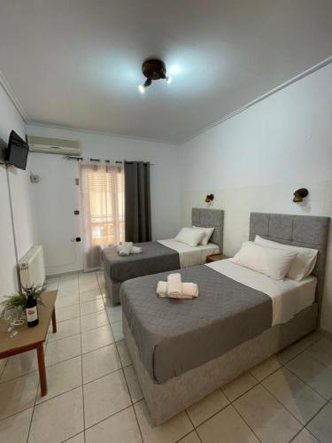 a hotel room with two beds and a table at Oscar Hotel Lefkada in Nydri