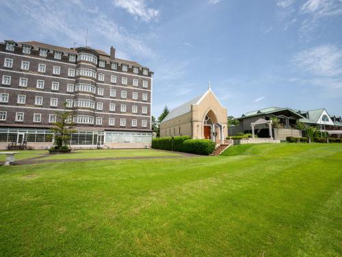 a large building with a green lawn in front of it at Wellness Forest Nasu in Nasu