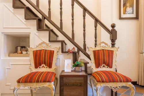 two chairs with striped cushions sitting under the stairs at Chuchaiburi Sri Amphawa in Amphawa