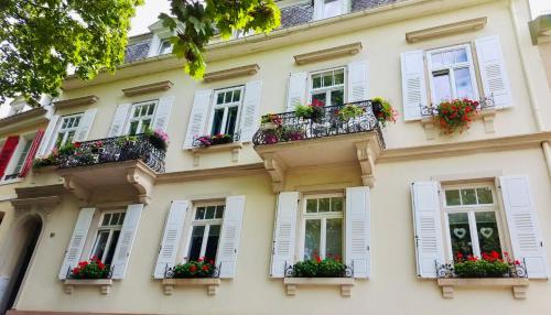 a building with white windows and flower boxes at Schloss Apartment, Zentrum Baden-Baden in Baden-Baden