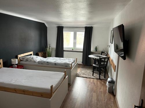 Kleines Zimmer mit 2 Betten und einem Tisch in der Unterkunft Piets Gästezimmer in Sandstedt