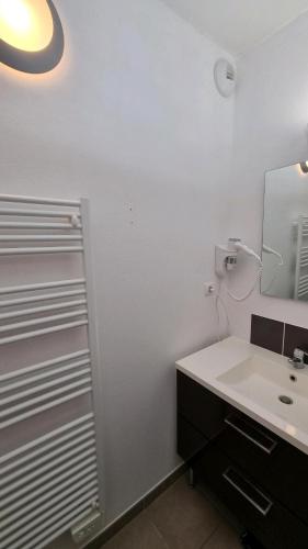 a bathroom with a sink and a mirror at AX proche départ rando - piscine - parking gratuit in Ax-les-Thermes