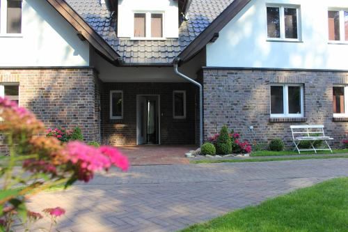 a brick house with a brick driveway at Lesny Apartament in Ostrzyce