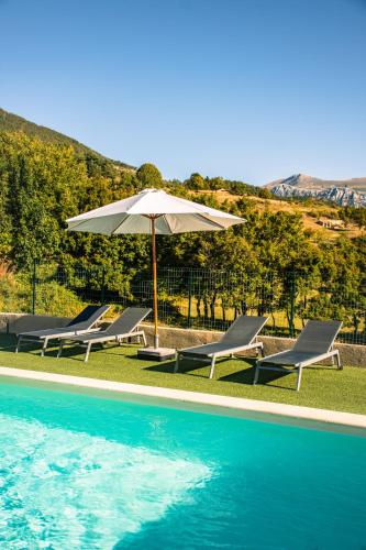 a group of chairs and an umbrella next to a pool at Hôtel le Panoramic - Votre Hôtel au cœur des Gorges du Verdon in La Palud sur Verdon