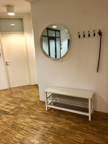 une chambre avec un miroir, un banc et une porte dans l'établissement Apartment Grindelallee Hamburg, à Hambourg
