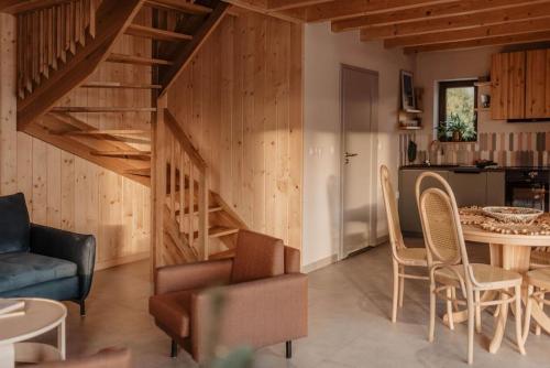 a living room with a staircase and a table and chairs at Chaty Jagi in Czorsztyn