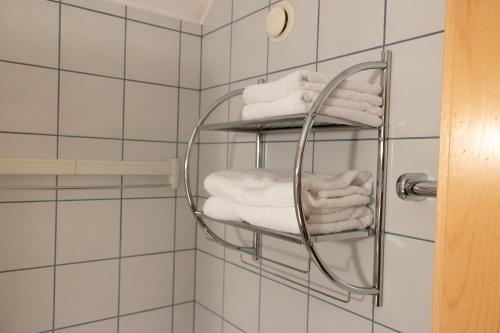 een handdoekenrek in de badkamer met witte handdoeken bij Pension Kärnten in Seeboden