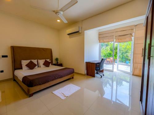 a bedroom with a bed and a desk and a window at HIDEOUT BY CMB APARTMENTS in Mount Lavinia