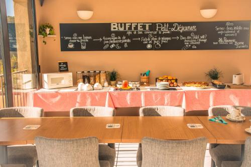a dining room with tables and a chalkboard at Hôtel le Panoramic - Votre Hôtel au cœur des Gorges du Verdon in La Palud sur Verdon