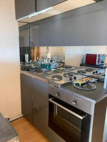 a kitchen with a sink and a stove top oven at 4 personnes in Chamrousse