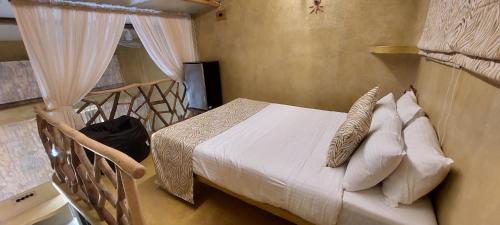 a bedroom with a bed with white sheets and pillows at Matsya in Havelock Island