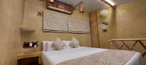 a bedroom with a bed with white sheets and pillows at Matsya in Havelock Island