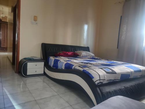 Un dormitorio con una cama y una mesita de noche. en Room Available Sharjah, en Sharjah