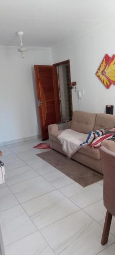 uma sala de estar com um sofá e uma mesa em Apartamento térreo, 2 quartos, 300m da praia de Atalaia, Aracaju em Aracaju