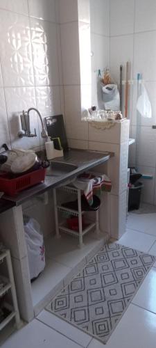 a kitchen with a counter and a sink in it at Apartamento térreo, 2 quartos, 300m da praia de Atalaia, Aracaju in Aracaju