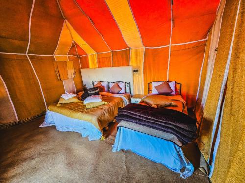 a room with two beds in a tent at Merzouga Tents © Official in Merzouga