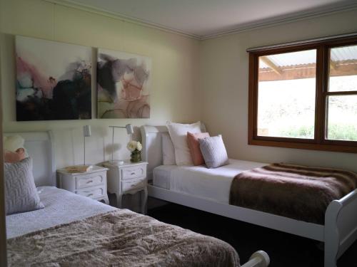 a bedroom with two beds and a window at Shawwood Cottage in Mudgee