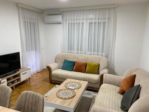 a living room with two couches and a tv at Apartment in Gjilan in Gnjilane