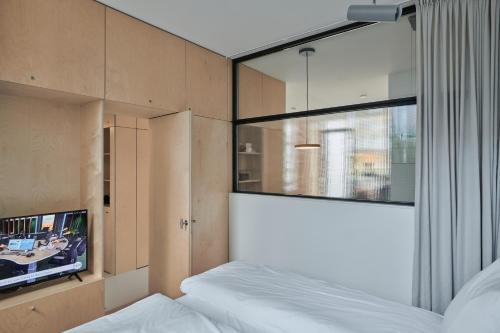 a bedroom with a bed and a tv on a wall at LE GARAGE Downtown serviced apartment in The Hague