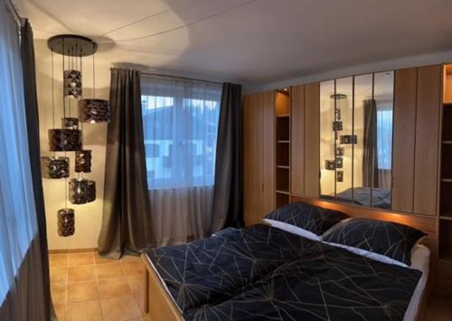 um quarto com uma cama e uma grande janela em Haus Schmidhuber Wohnung 3 em Grossgmain