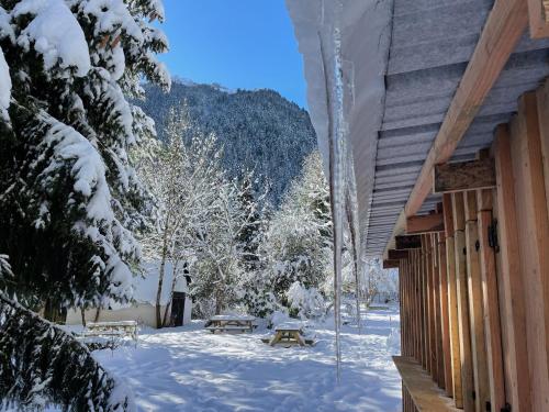a snow covered yard next to a cabin at Hotel O Chiroulet in Bagnères-de-Bigorre