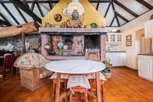 a living room with a fireplace and a table at Casa Grande da Camélia in São Vicente