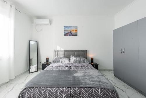 a bedroom with a large bed and a mirror at Kilian Apartment in Shkodër