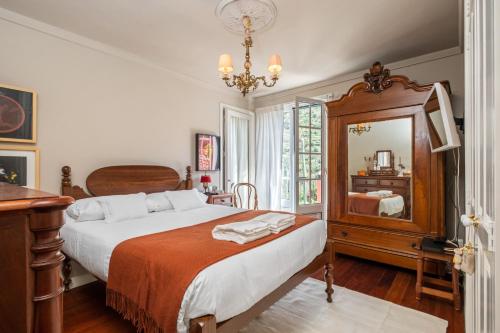 a bedroom with a bed and a mirror at Casa Grande da Camélia in São Vicente