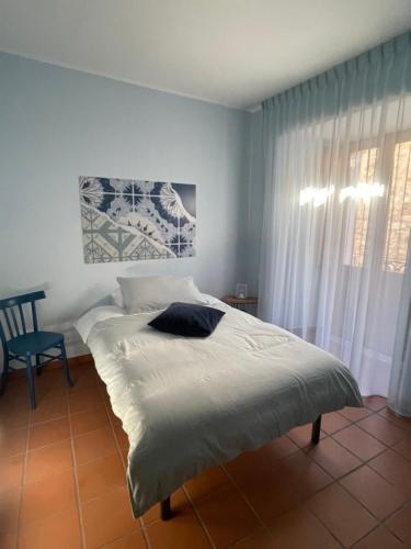 a bedroom with a bed and a chair and a window at Casa Cuoco in Civita Campomarano