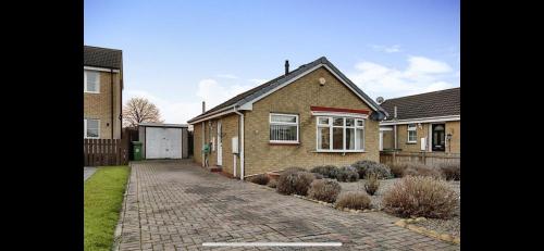 a brown brick house with a brick driveway at Sunset Cottage in Stockton-on-Tees