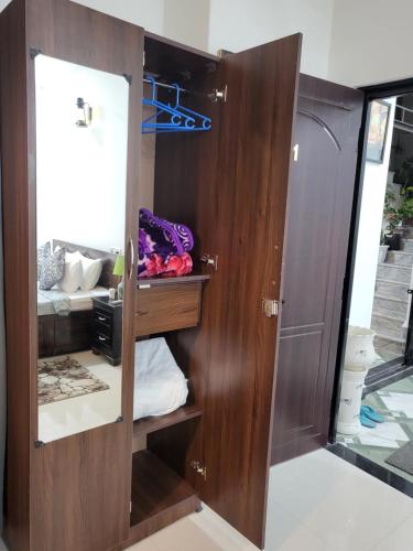 a wooden cabinet with a mirror in a room at Hebron Haven in Jaigaon