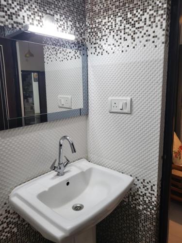 a bathroom with a sink and a mirror at Hebron Haven in Jaigaon